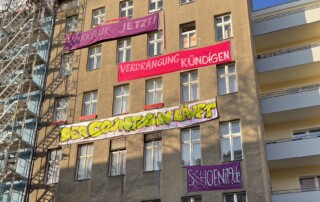 Fassade des Gebäudes Schönleinstraße 19 mit Demo Bannern